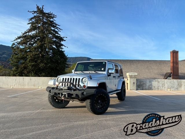 2010 Jeep Wrangler Unlimited Sahara in Bright Silver Metallic Clearcoat/Black Soft Top — front three-quarter view